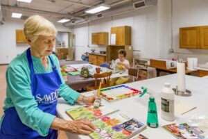 Residents painting flowers and doing crafts in community art center
