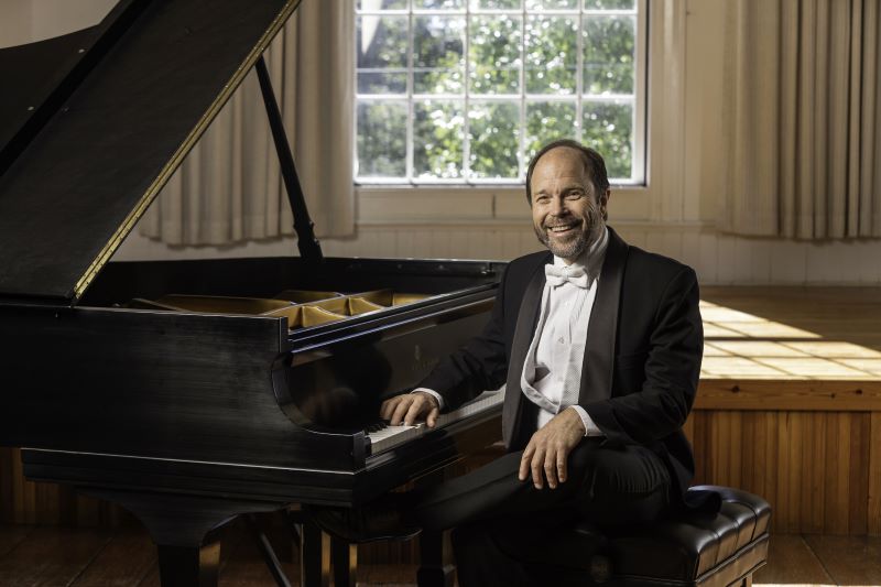 fred moyer posing next to a piano