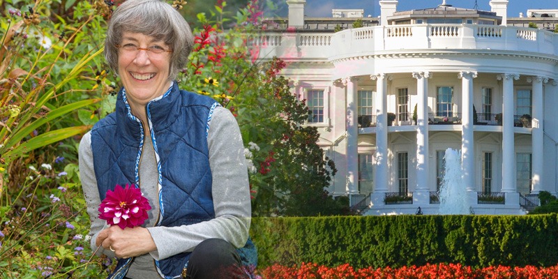 woman in her garden in front of the white house